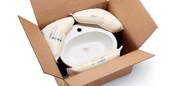 Un carton contenant un lavabo et du rembourrage en mousse